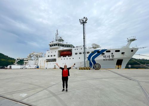 A person standing in front of a vessel.