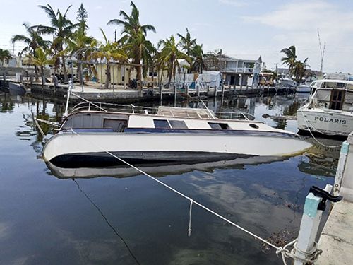 A boat, tipped on its side, floating in the water. 