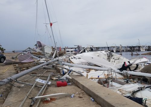 Wrecked boats, piled up along a dock.