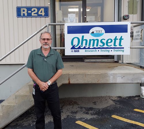 Man standing next to a sign.