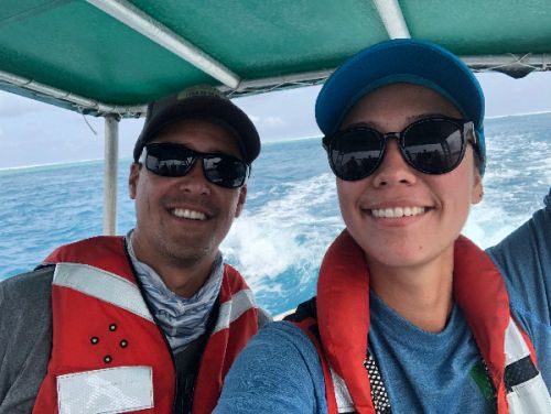 Two people on a boat smiling.