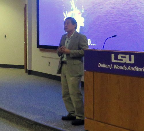 Man speaking next to a lectern.