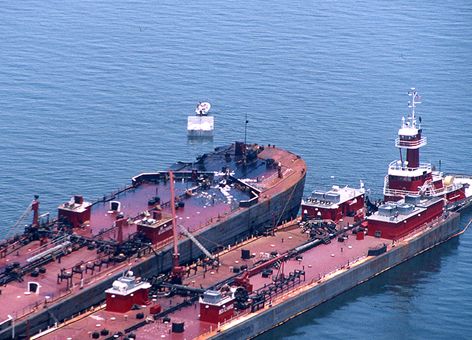 Two large vessels next to each other in the water.
