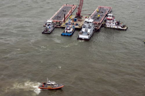 A barge, bulk carrier, and smaller boat on the water. 