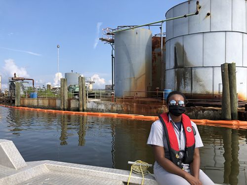 Person in front of a damaged oil tank.