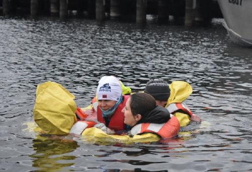 A group of people in the water, huddling together. 