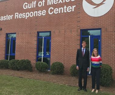 Two people in front of a building that reads "Gulf of Mexico Disaster Response Center." 