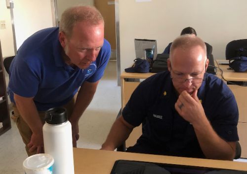 Two men looking a computer screen.