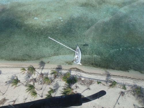 Aerial view of a sailboat aground near a beach.
