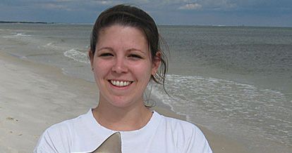 A photo of a woman with the ocean in the background. .