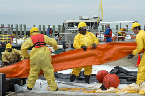 Cleanup workers hauling pollution boom.