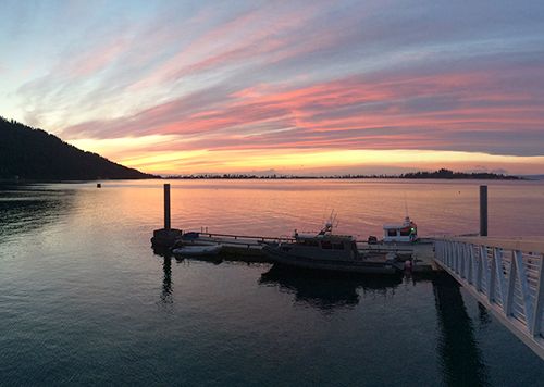 Sunset over water with building in foreground.