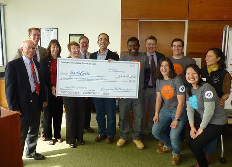 A group of people holding a giant check for $4.9 million.