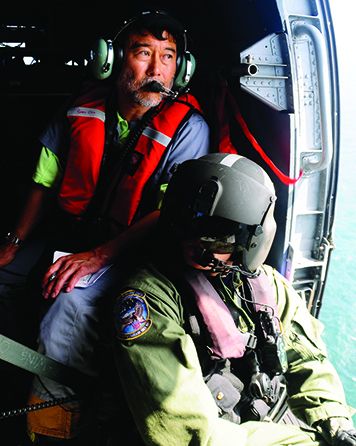 Overflight surveys from airplanes or helicopters help responders find oil slicks as they move and break up across a potentially wide expanse of water. They give snapshots of where the oil is located and how it is behaving at a specific date and time, which NOAA uses to compare to our oceanographic models. (U.S. Coast Guard) Two people in a helicopter over water.