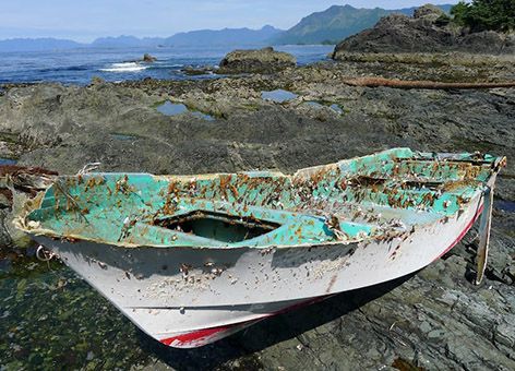 Small boat on rocky shoreline.