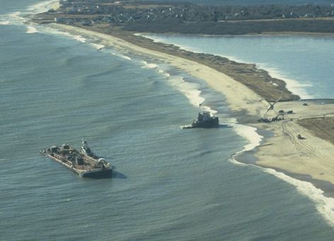 A ship and tug grounded on the shore.