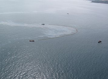 Boats skimming oil off the ocean surface.