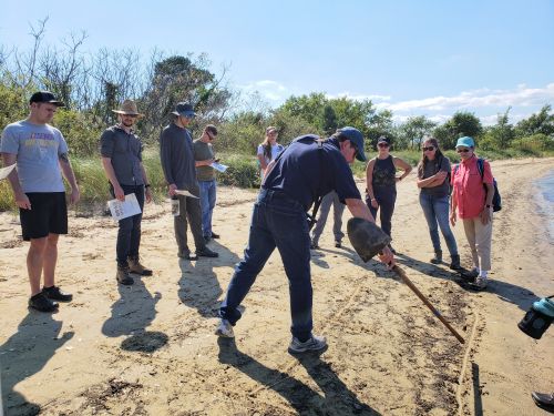 Training participants standing on a beach. 