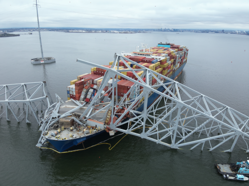 An aerial view of a bridge collapsed on a cargo ship that crashed into it.