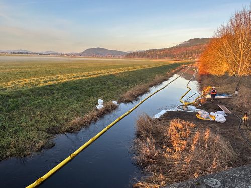 The Olympic Pipeline spill emergency response in Conway, WA. View of Hill Ditch looking north from SR 534. Gasoline is captured by the boom on the right side of the ditch and removed from the ditch by a skimmer. 