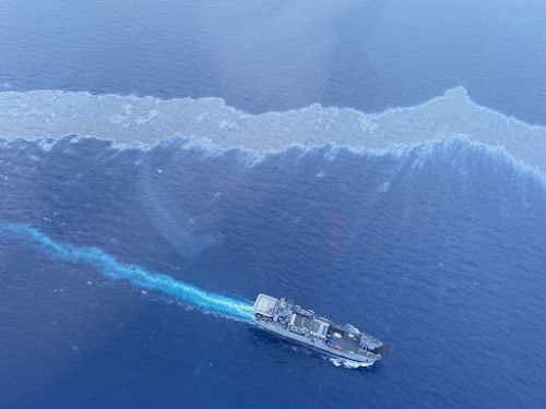 An aerial image of a boat near an oil sheen.