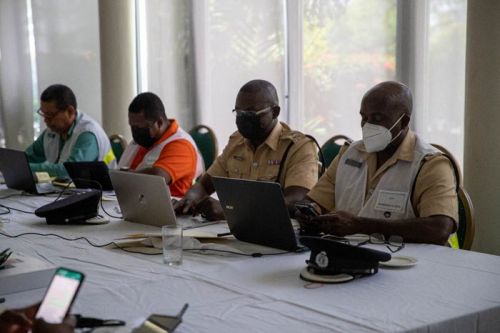 A group of people at a table with laptops.