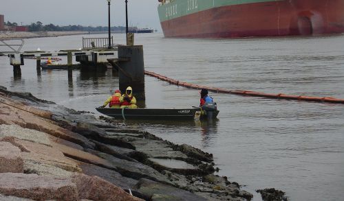 Workers clean oil from rocks following spill. Workers clean oil from rocks following spill.