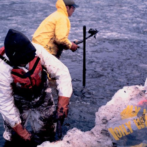 Workers clean spilled oil from ship grounding. Workers clean spilled oil from ship grounding.