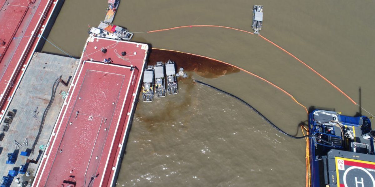 An aerial view of oil in a pollution boom along a barge.