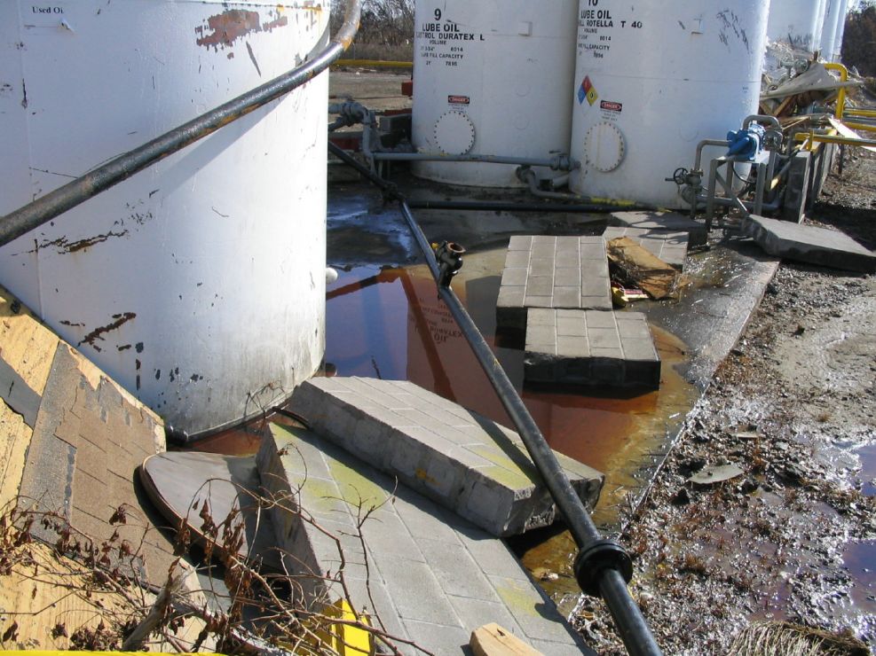 Displaced oil tanks with oil pooled around them.