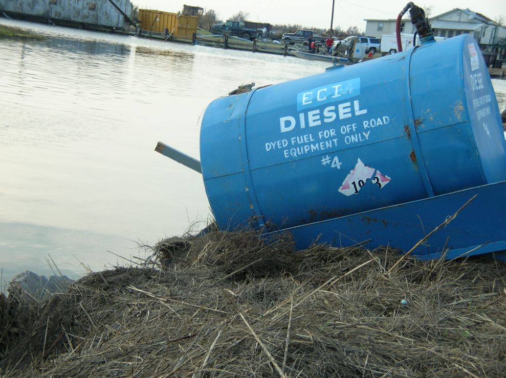 Diesel container on an embankment next to water. 