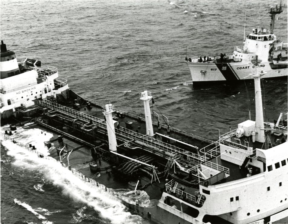 A Coast Guard vessel near a foundering ship.
