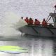 People in a boat spraying green dye into Arctic Ocean.