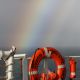 Rainbow over the edge of a ship with a life preserver.