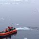 Coast Guard members in small boat on Arctic Ocean.