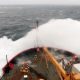 Large wave breaking on the bow of a ship.