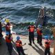Ship crew lowers a oceanographic instrument into the ocean.