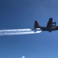 Plane flying over the surface, spraying water