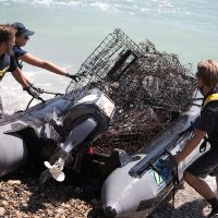 People remove traps on a boat from water.