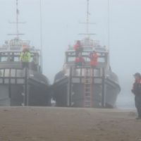 Two boats in fog with man on beach. Image: NOAA.