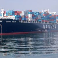 A large shipping vessel loaded with containers. A gash appears on the port side over the text "Hanjin."