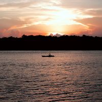 A kayaker on the water at sunset.