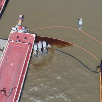 Overhead view of  docks and bow of ship with oil in the water. 