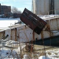 Sinking vessel near an industrial area. 