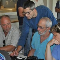 Four people looking at a computer. 