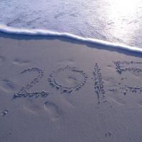2015 written on a sandy beach with an approaching wave.