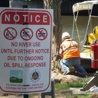 Posted sign closing river activity due to oil spill response.