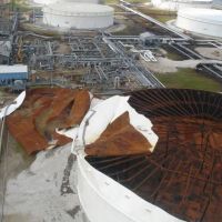 A Chevron oil terminal’s storage tank with severe damage on top.