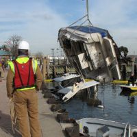 A response team oversees the removal of a sunken boat that was discharging oil.