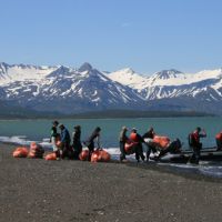 GYRE Expedition participants loading bags of debris from Hallo Bay onto a boat.